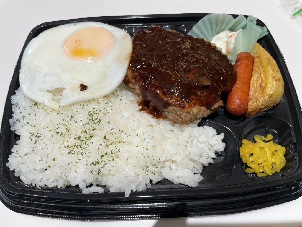 デミグラスソースがかかったハンバーグ、目玉焼き、ご飯が盛り付けられたお弁当