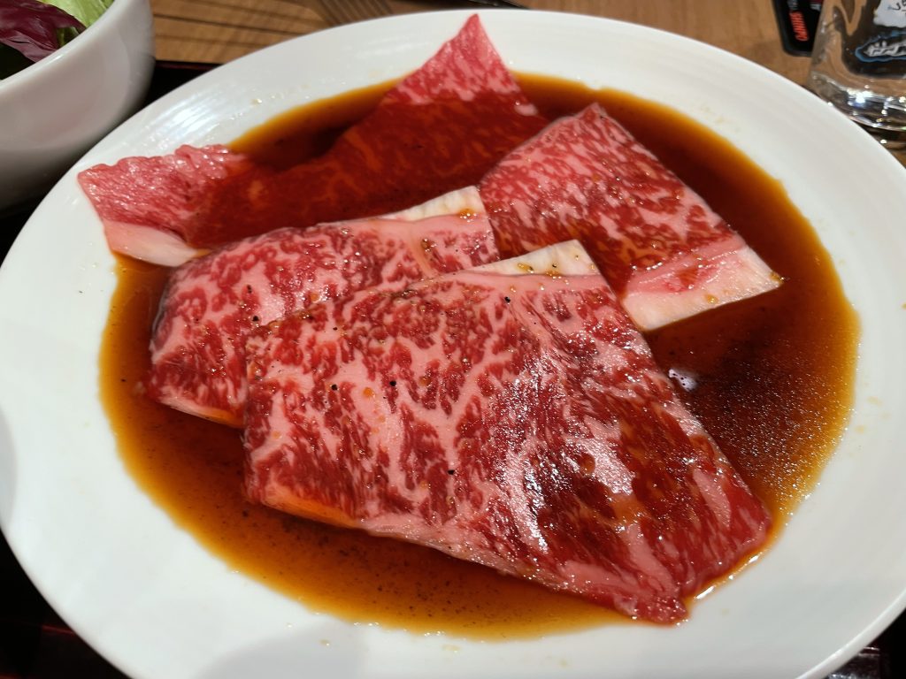 醤油ベースのタレに漬け込まれた、霜降りの鮮やかな焼肉用牛ロース肉